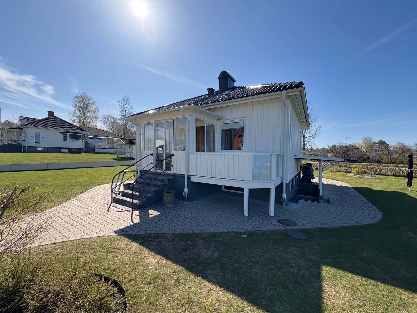 Ny inglasad farstu med trappa på en vit villa i Otterbäcken