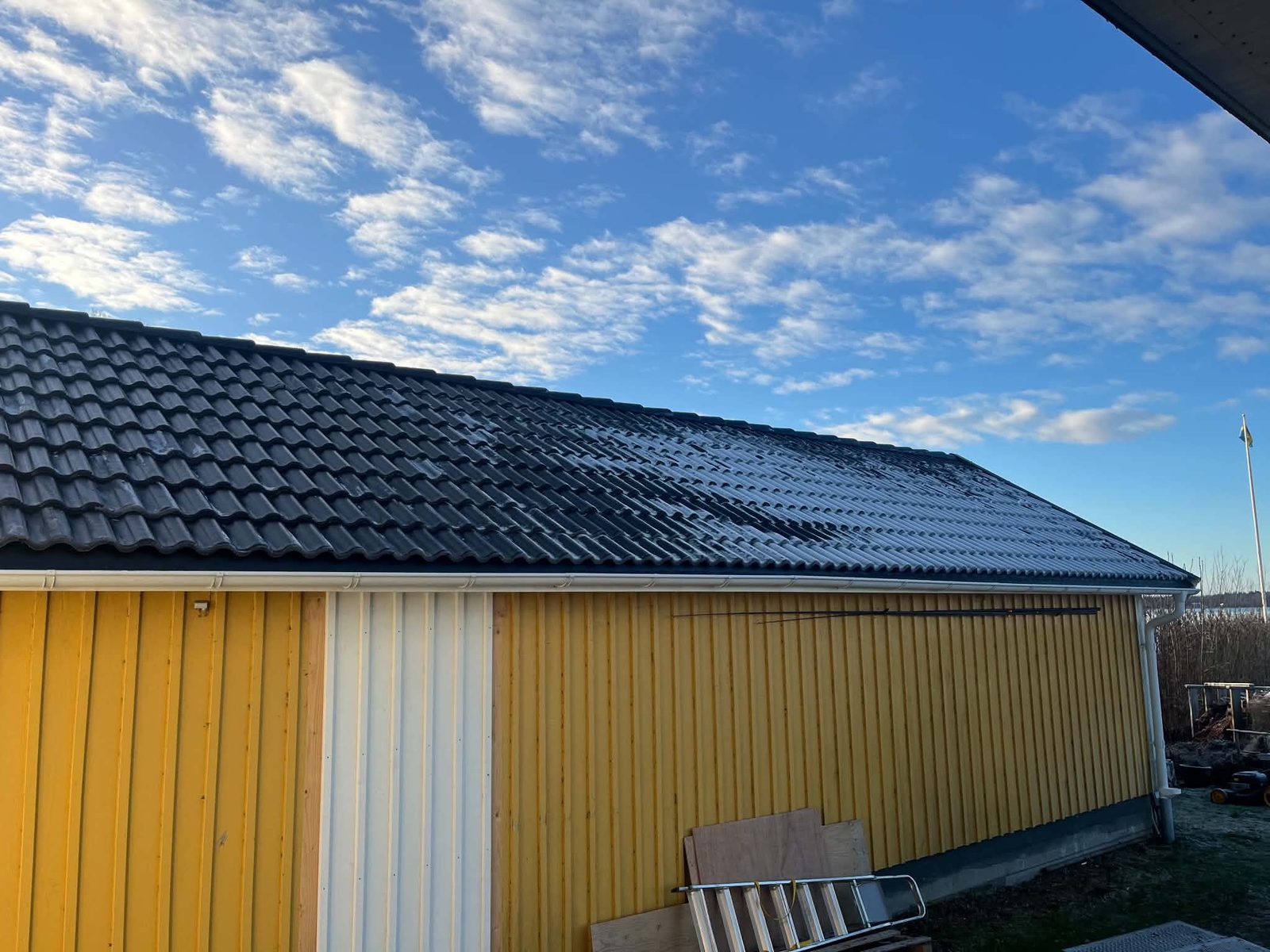 Nytt tak med svarta takpannor på ett gult hus i Otterbäcken